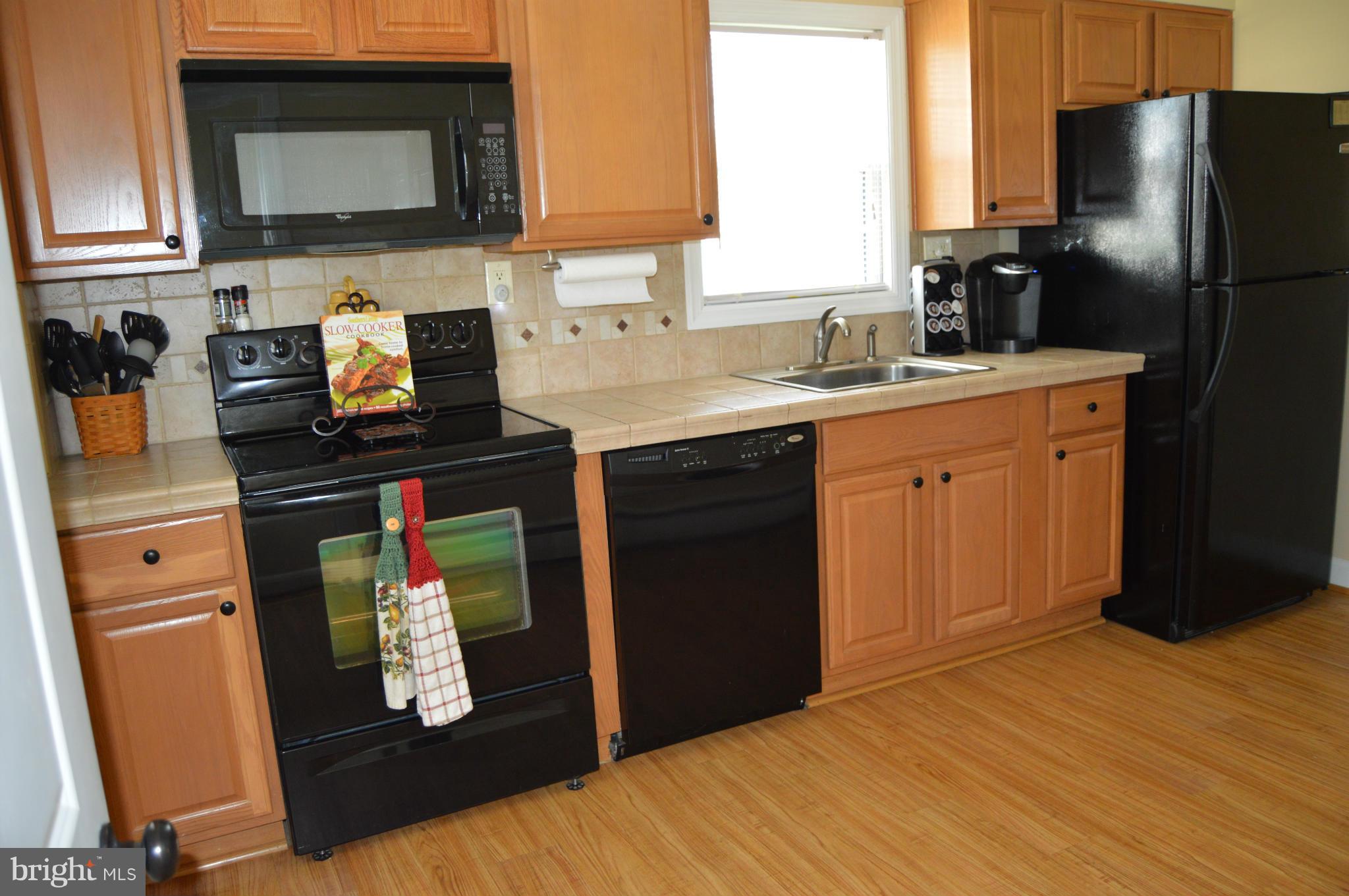 8471 Church Road Pasadena, MD 21122 - Photo 5 of 18 a kitchen with stainless steel appliances a refrigerator stove and sink