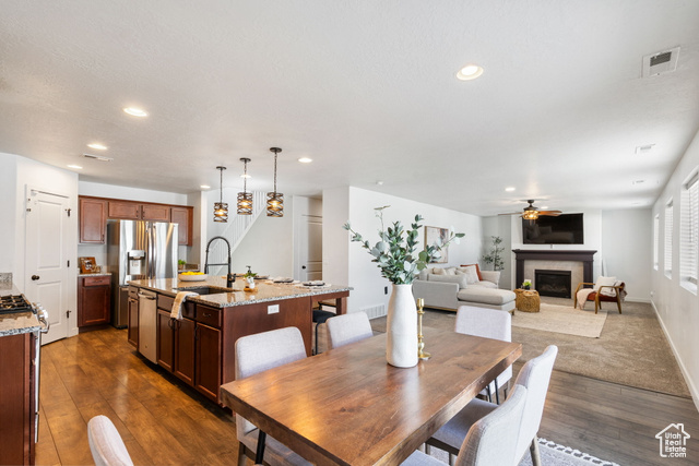 3456 South Linden Way Syracuse, UT 84075 - Photo 2 of 50 Dining area with a ceiling fan, dark wood-style floors, recessed lighting, a glass covered fireplace, and baseboards