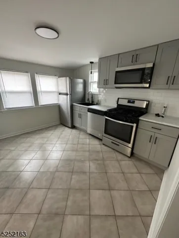 a kitchen with stainless steel appliances a sink a stove a microwave and cabinets