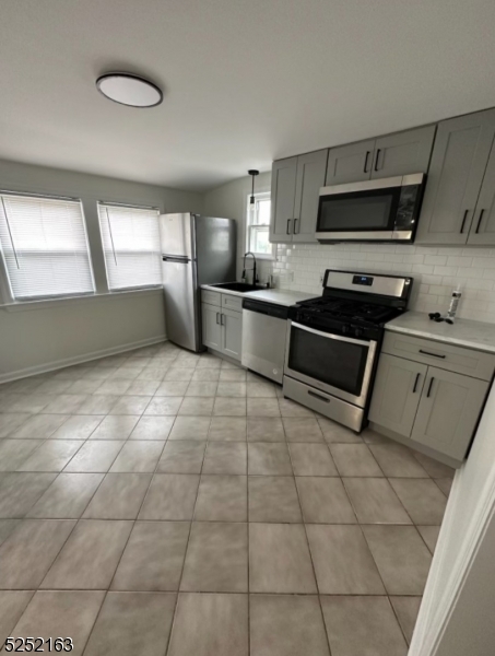 a kitchen with stainless steel appliances a sink a stove a microwave and cabinets