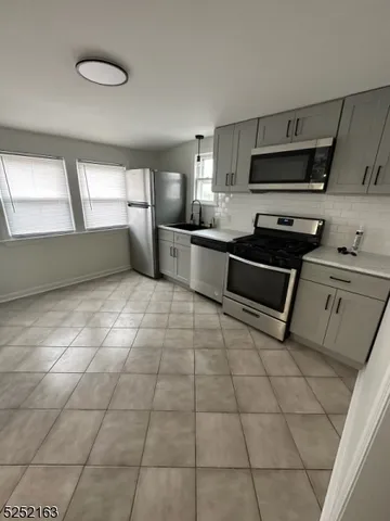 a kitchen with stainless steel appliances a sink a stove a microwave and cabinets