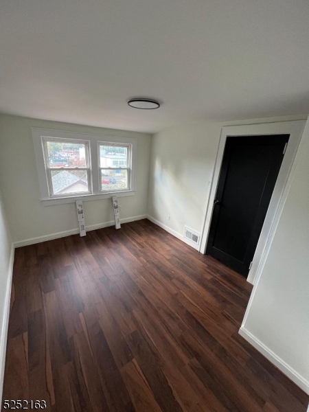 1026 Woolley Avenue Union, NJ 07083 - Photo 7 of 7 a view of an empty room with wooden floor and a window