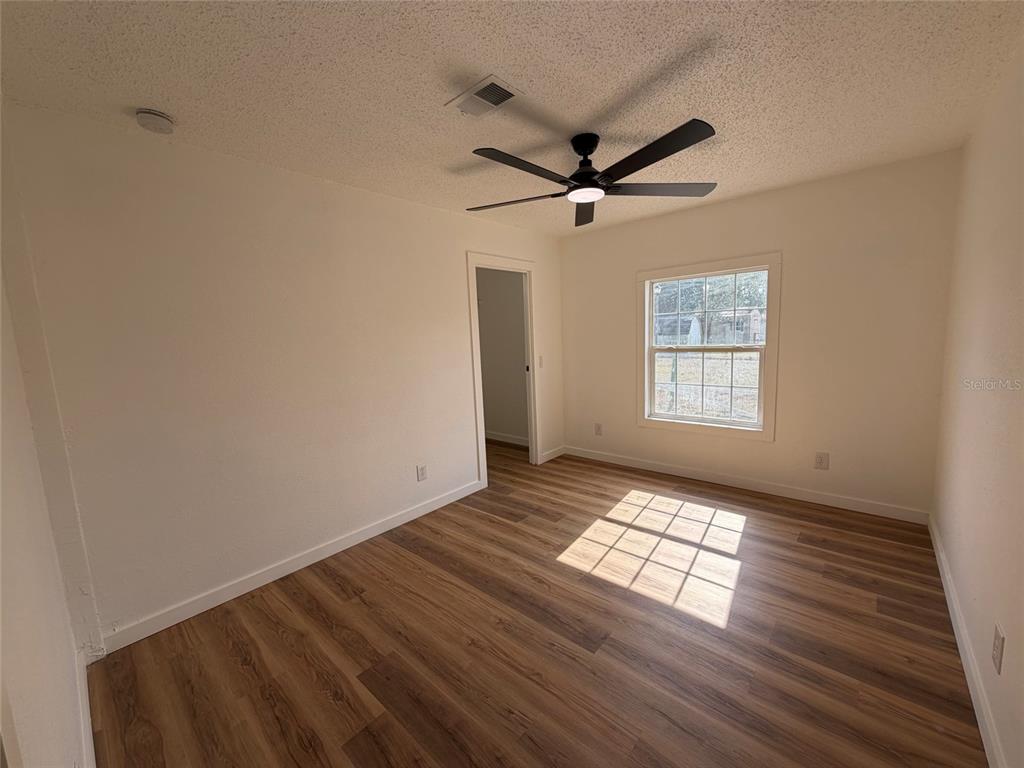 28834 Hubbard Street Leesburg, FL 34748 - Photo 19 of 22 a view of empty room with wooden floor and fan