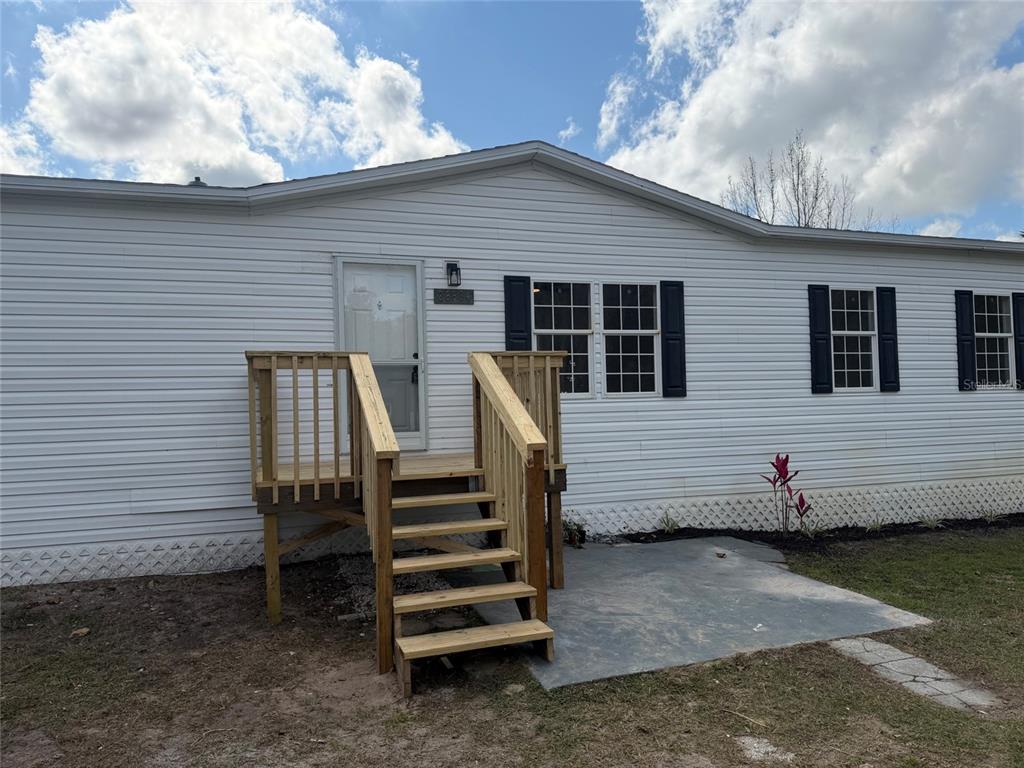 28834 Hubbard Street Leesburg, FL 34748 - Photo 6 of 22 a view of a patio with a table and chairs a barbeque with wooden fence