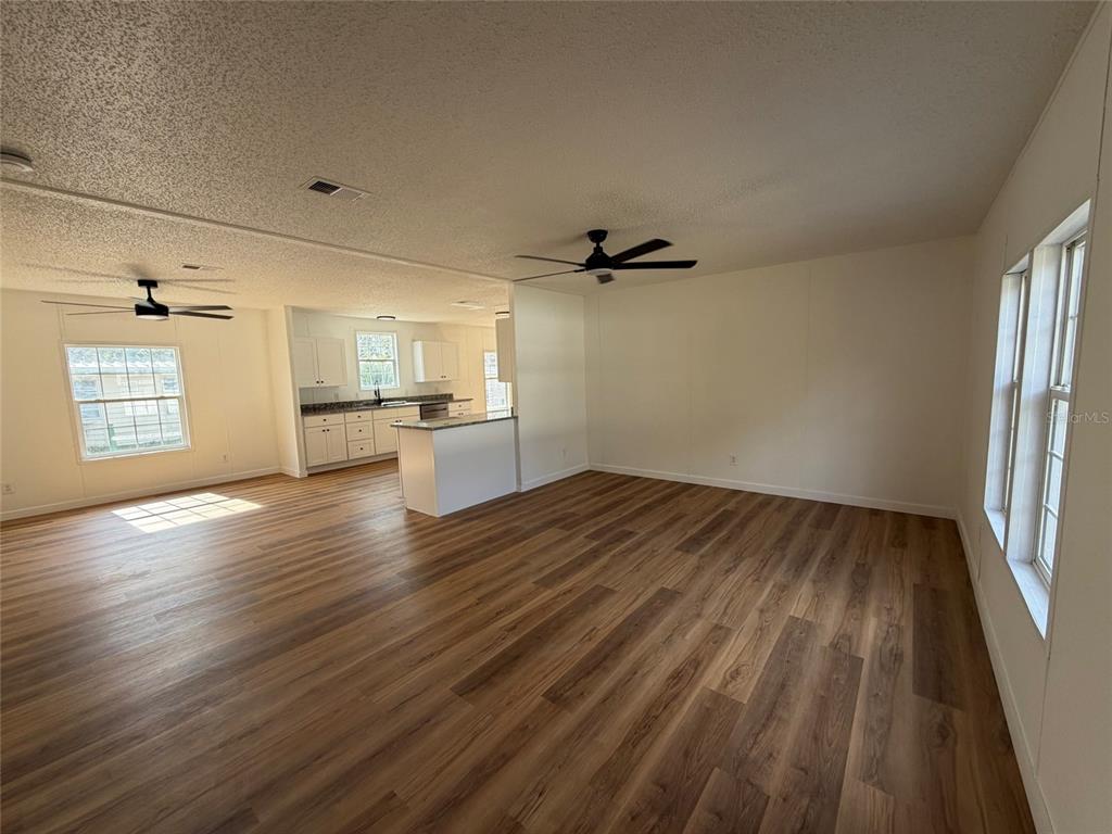28834 Hubbard Street Leesburg, FL 34748 - Photo 7 of 22 wooden floor in an empty room with a window