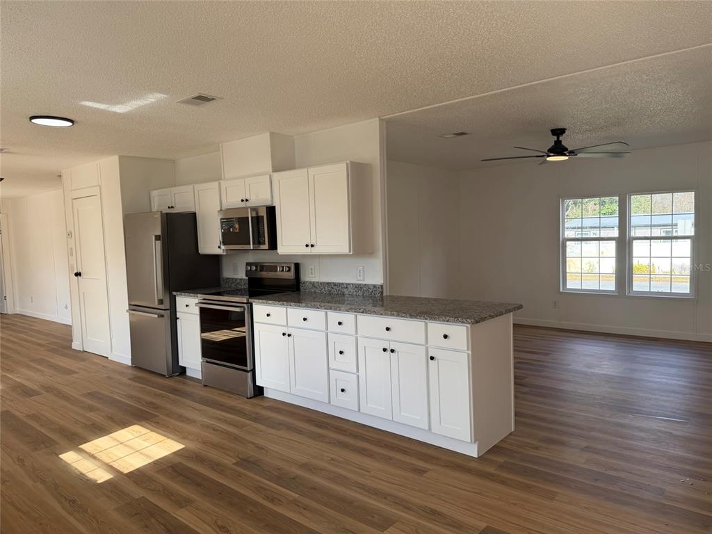 28834 Hubbard Street Leesburg, FL 34748 - Photo 10 of 22 a kitchen with granite countertop a refrigerator stove and sink