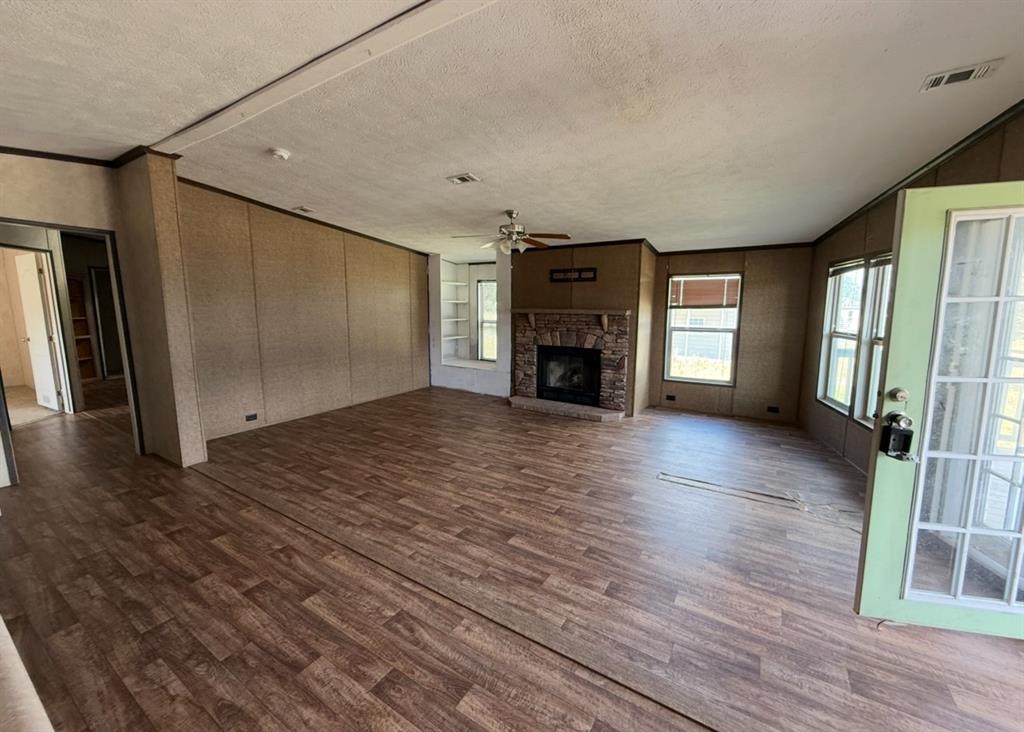 221 Farmhouse Road Springtown, TX 76082 - Photo 9 of 23 a view of empty room with wooden floor and fireplace
