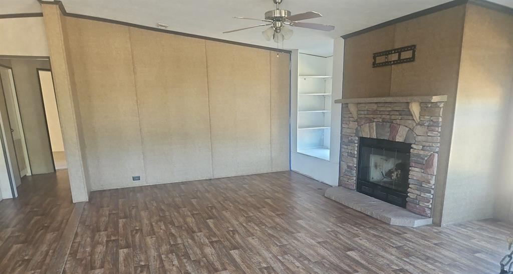221 Farmhouse Road Springtown, TX 76082 - Photo 10 of 23 a view of an empty room with wooden floor and a fireplace