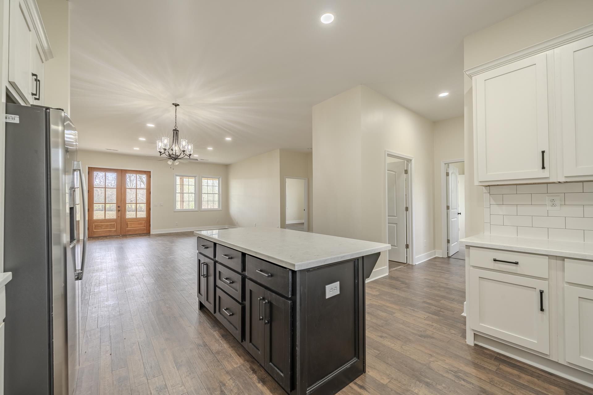 1030 Robbins Road Collinwood, TN 38450 - Photo 39 of 40 Kitchen with open floor plan, stainless steel refrigerator with ice dispenser, a kitchen island, tasteful backsplash, and two tone cabinets
