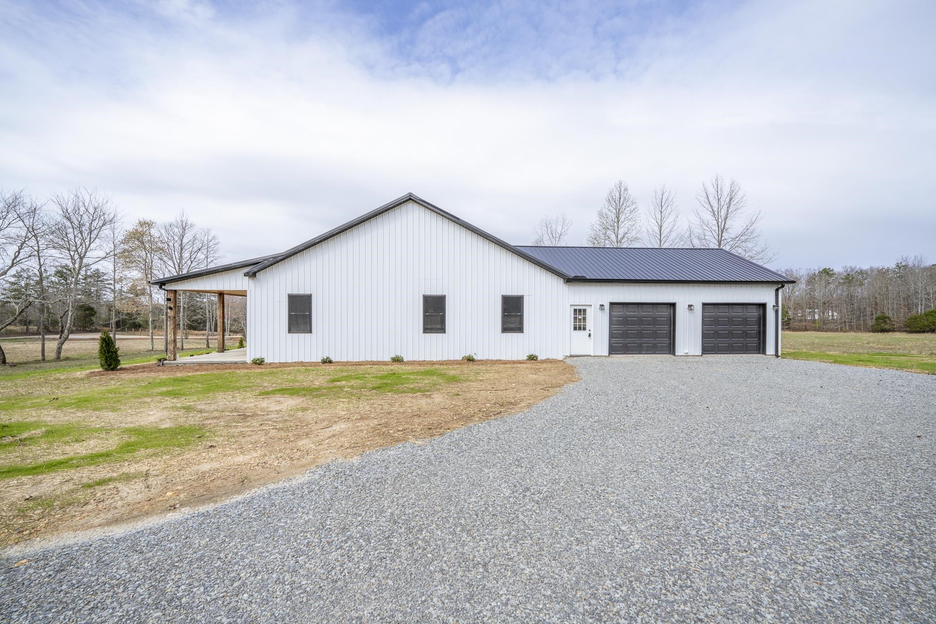1030 Robbins Road Collinwood, TN 38450 - Photo 4 of 40 View of side of property with gravel driveway, a metal roof, and a garage