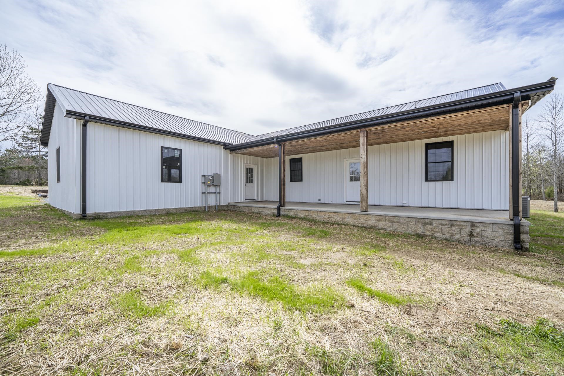 1030 Robbins Road Collinwood, TN 38450 - Photo 5 of 40 Rear view of house featuring a metal roof, a yard, and covered porch