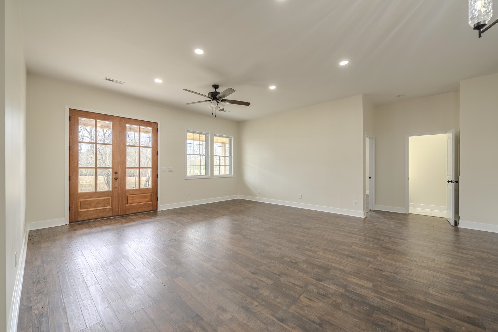 1030 Robbins Road Collinwood, TN 38450 - Photo 7 of 40 Empty room with recessed lighting, french doors, dark wood-style floors, and a ceiling fan
