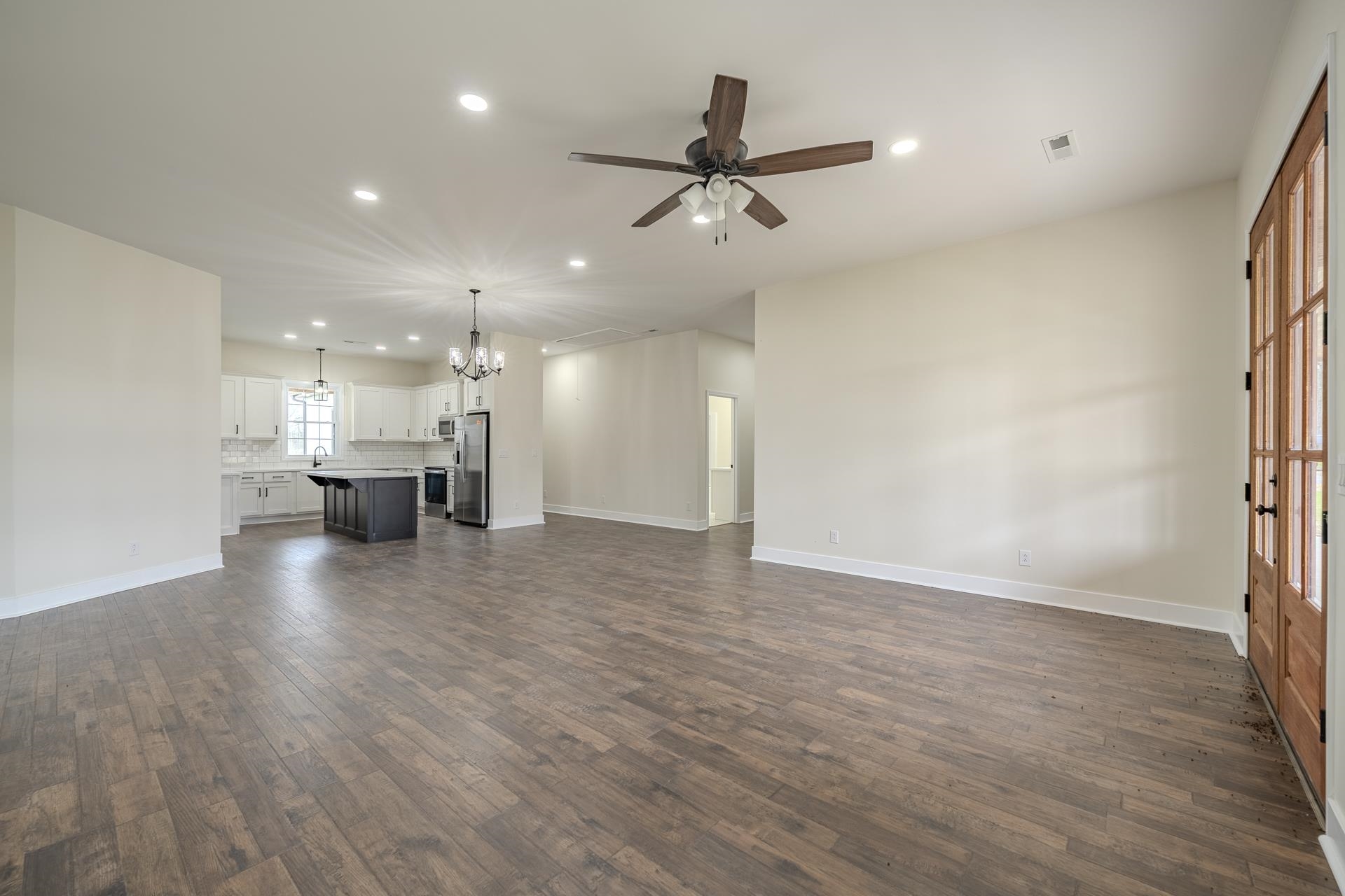 1030 Robbins Road Collinwood, TN 38450 - Photo 10 of 40 Unfurnished living room with ceiling fan, dark wood-style floors, and a chandelier