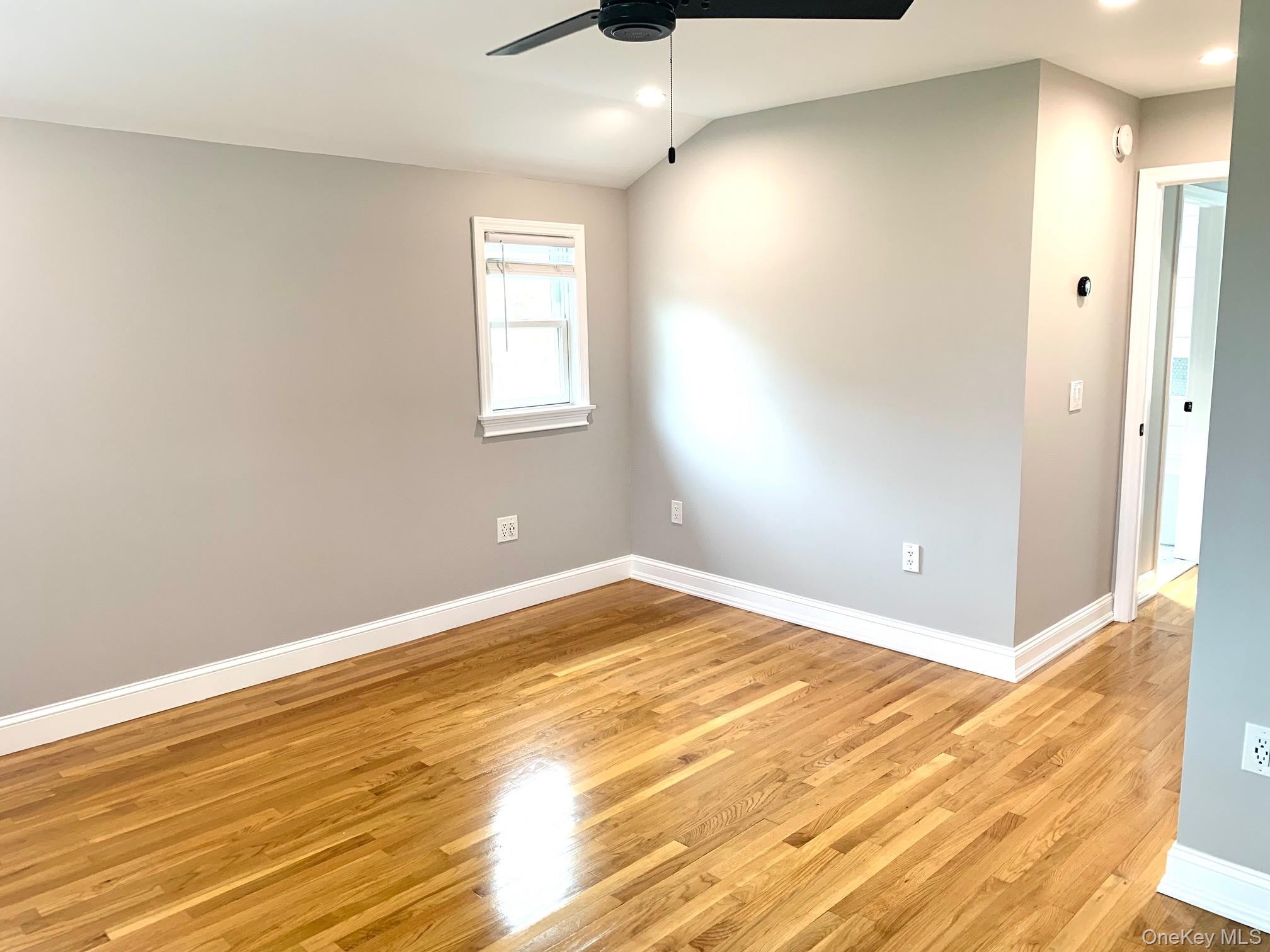 435 Middle Road Riverhead, NY 11901 - Photo 11 of 19 an empty room with wooden floor and windows