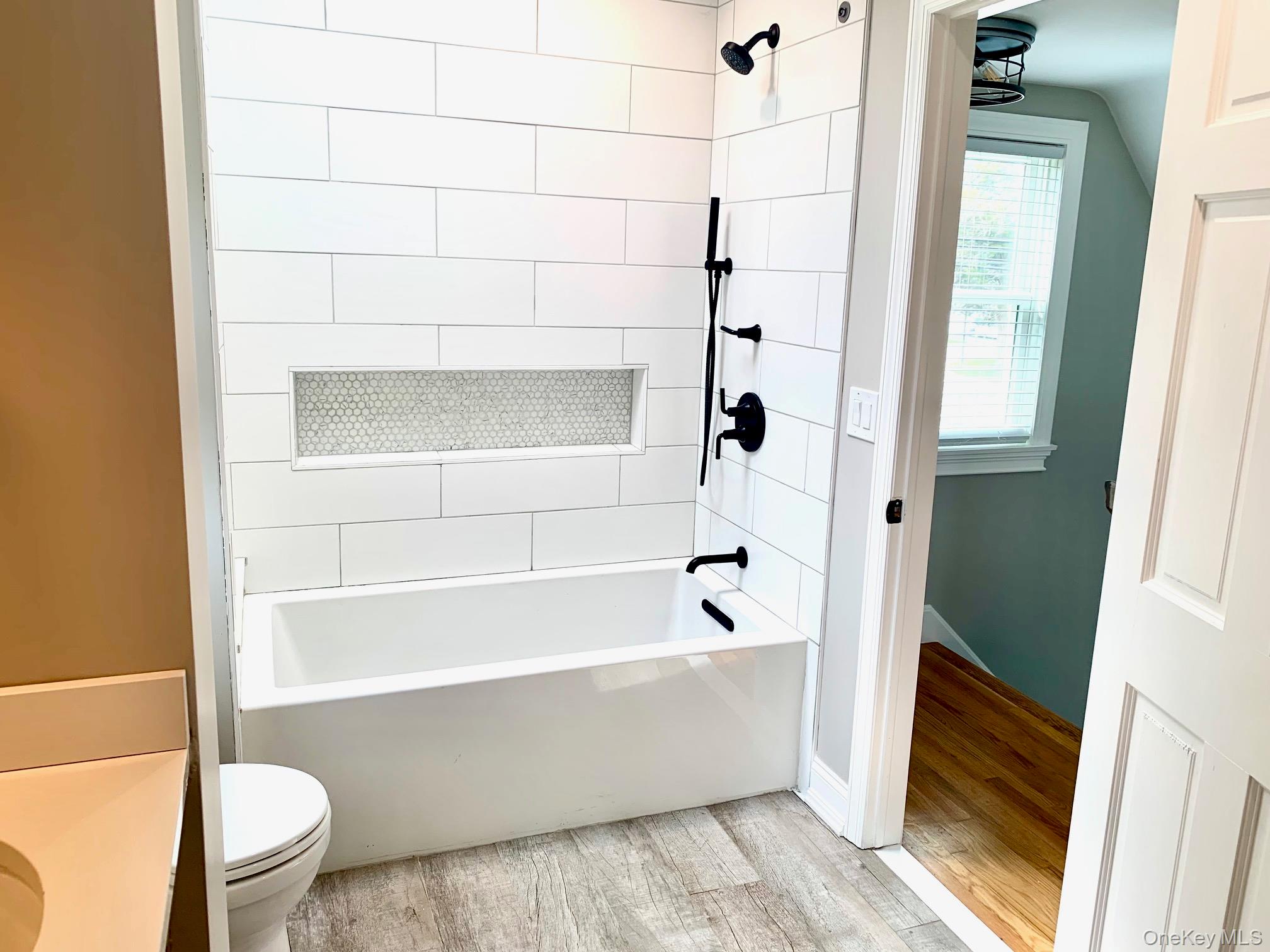 435 Middle Road Riverhead, NY 11901 - Photo 14 of 19 a bathroom with a bathtub and a toilet