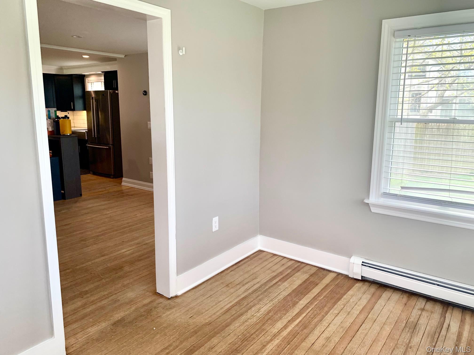 435 Middle Road Riverhead, NY 11901 - Photo 17 of 19 an empty room with wooden floor and windows