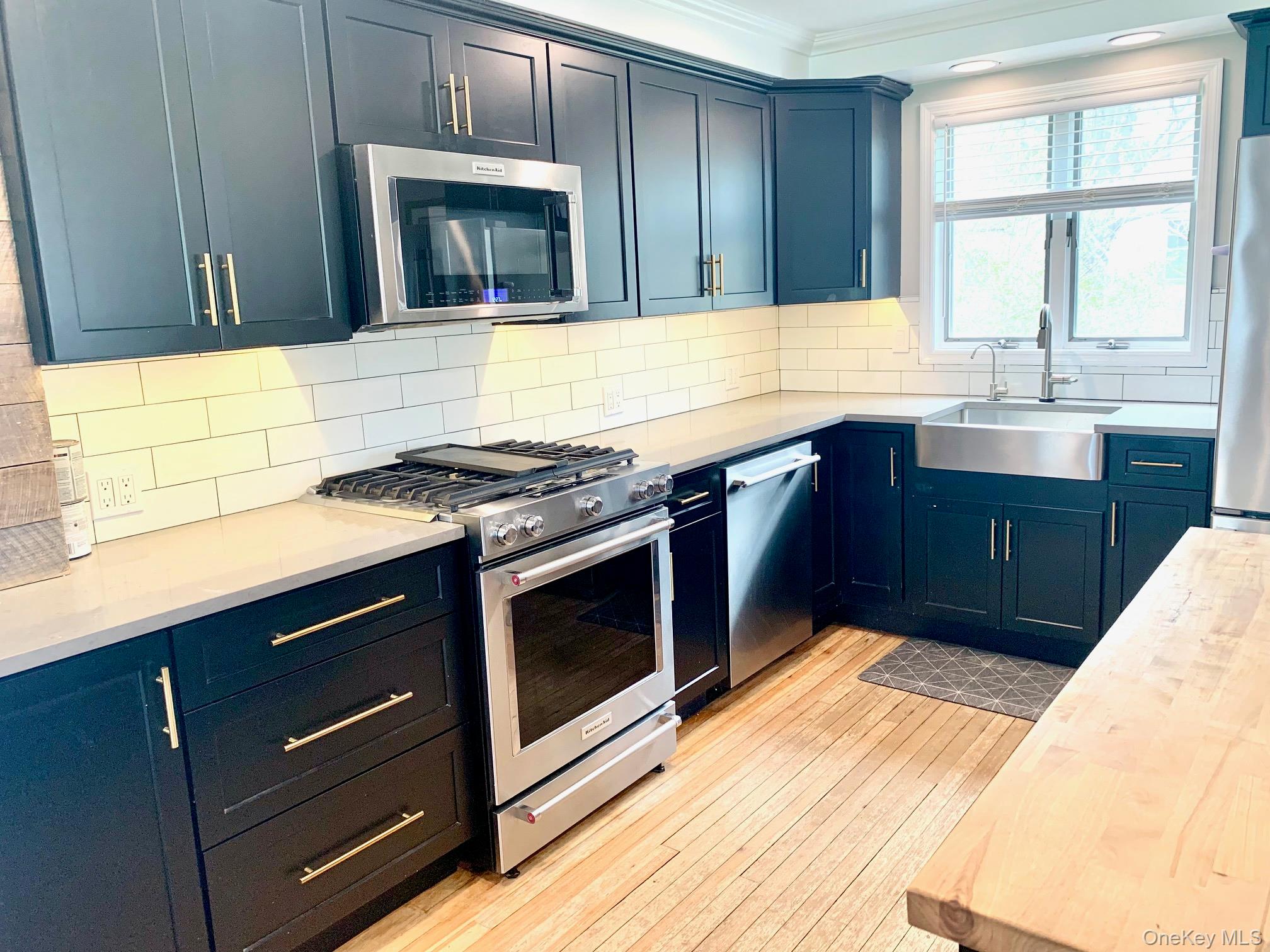 435 Middle Road Riverhead, NY 11901 - Photo 3 of 19 a kitchen with stainless steel appliances granite countertop wooden cabinets and a stove top oven