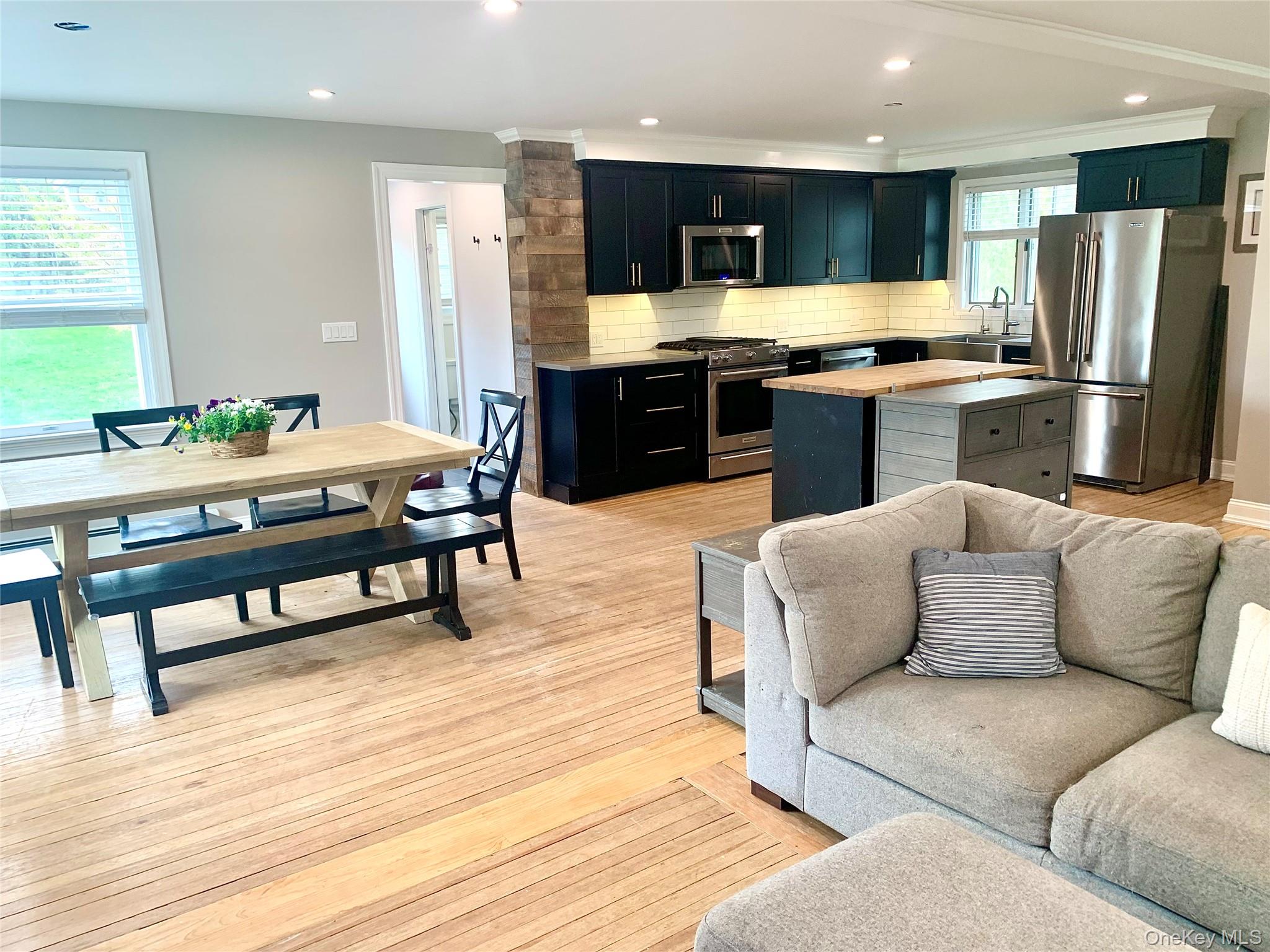 435 Middle Road Riverhead, NY 11901 - Photo 4 of 19 a living room with stainless steel appliances furniture and a kitchen view