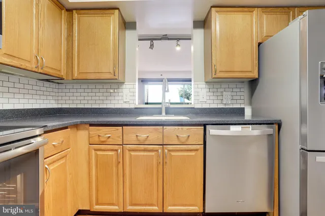 a kitchen with stainless steel appliances white cabinets and a window