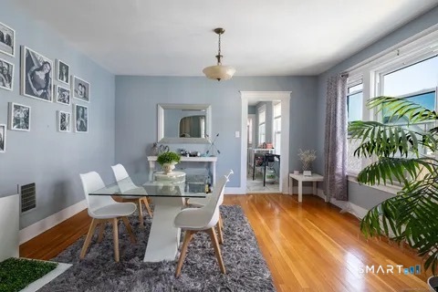154 Rose Street Bridgeport, CT 06610 - Photo 6 of 6 a dining room with furniture potted plants and wooden floor