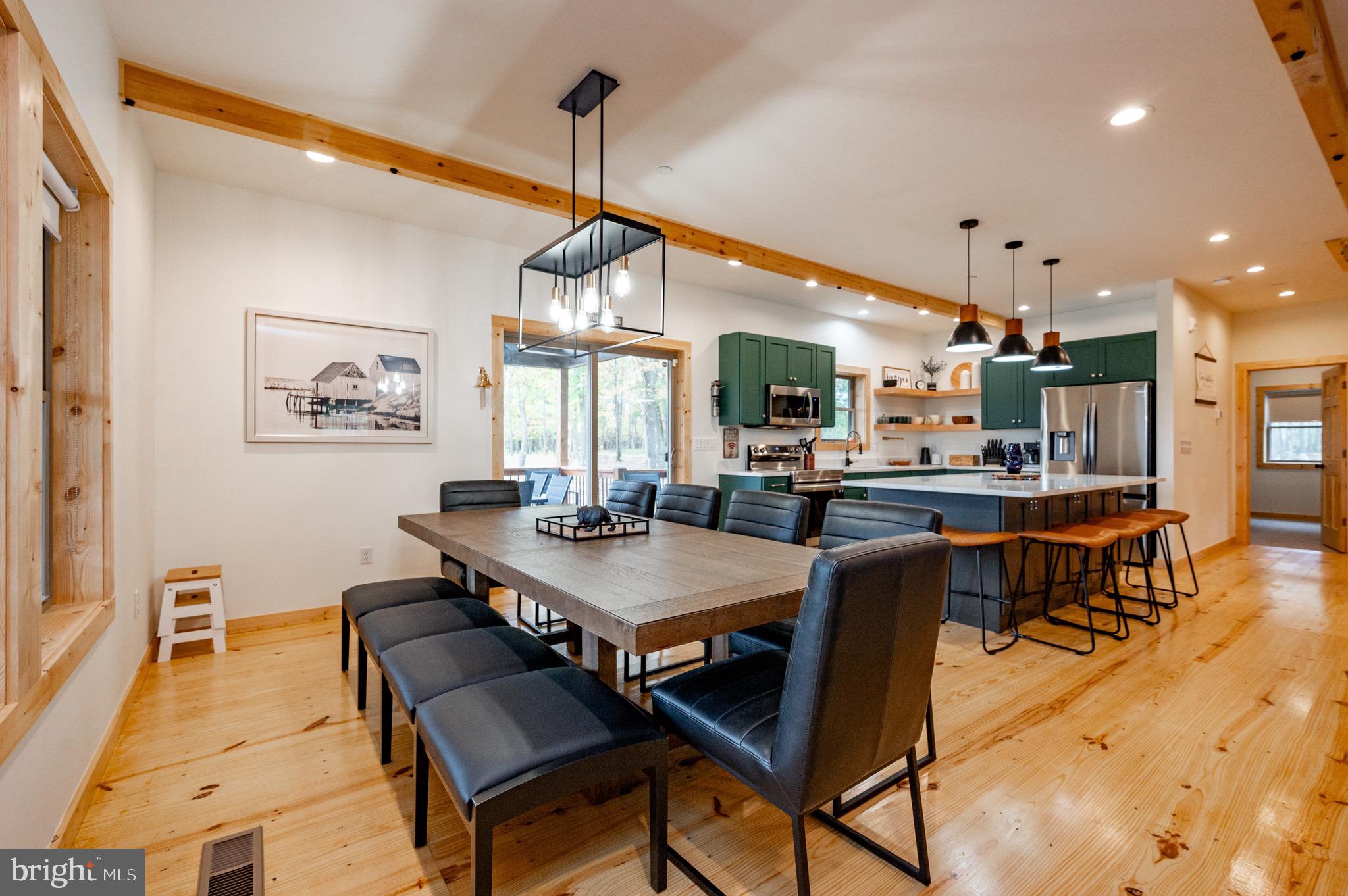 36 Irwin Way Oakland, MD 21550 - Photo 17 of 64 a view of a dining room and livingroom with furniture wooden floor a rug a painting and a chandelier