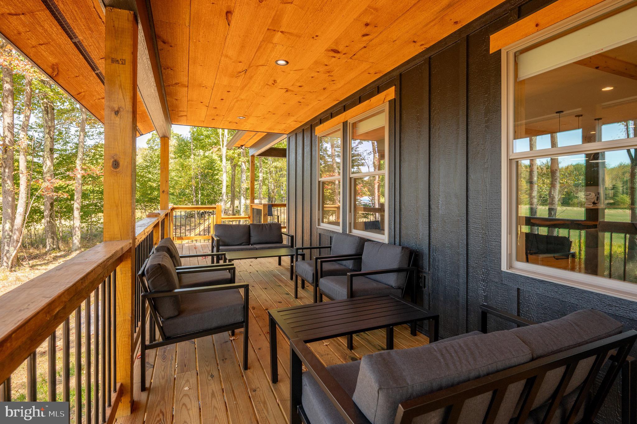 36 Irwin Way Oakland, MD 21550 - Photo 23 of 64 a view of a patio with couches chairs potted plants and wooden floor