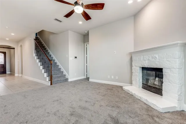 an empty room with windows and fireplace