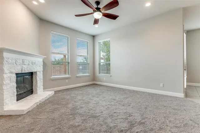 a view of an empty room with window and fire place