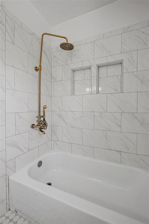 3225 Windsor Avenue Waco, TX 76708 - Photo 15 of 25 Bathtub with white subway tile surround featuring a subtle grey veining pattern