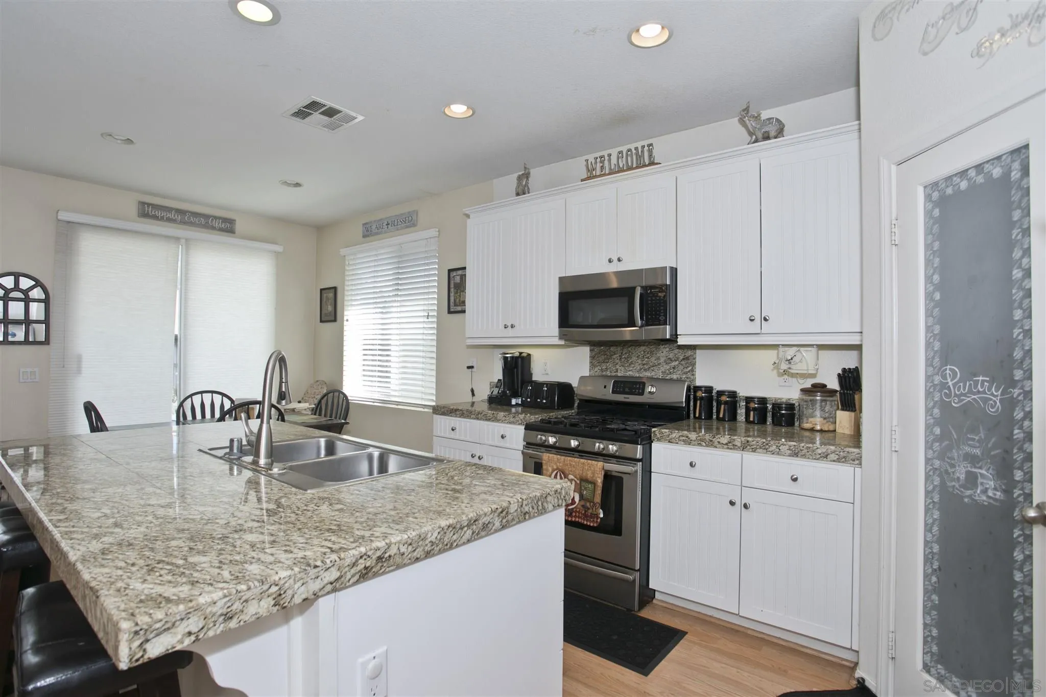 4660 Duskywing Road Hemet, CA 92545 - Photo 2 of 29 a kitchen with stainless steel appliances granite countertop a sink dishwasher a stove and a refrigerator with wooden floor