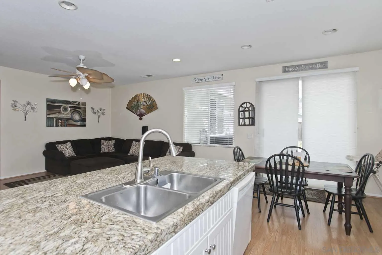 4660 Duskywing Road Hemet, CA 92545 - Photo 4 of 29 a kitchen with granite countertop a table chairs and a wooden floor