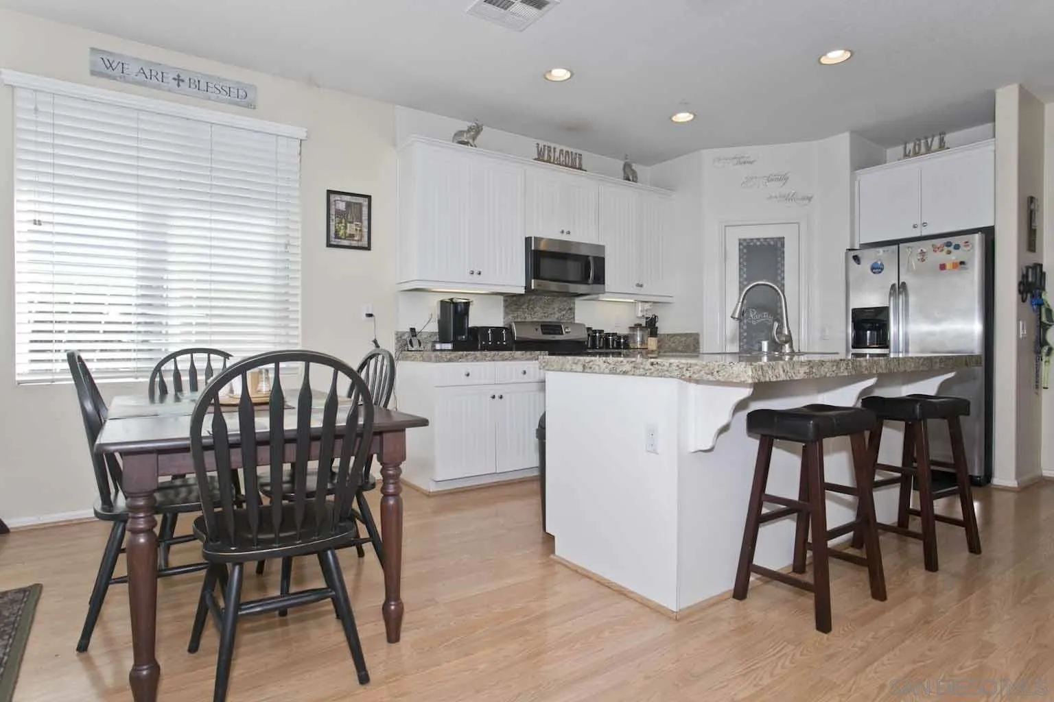4660 Duskywing Road Hemet, CA 92545 - Photo 5 of 29 a kitchen with stainless steel appliances kitchen island granite countertop a dining table chairs and a refrigerator