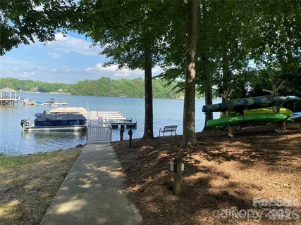a view of a lake with lawn chairs under an umbrella