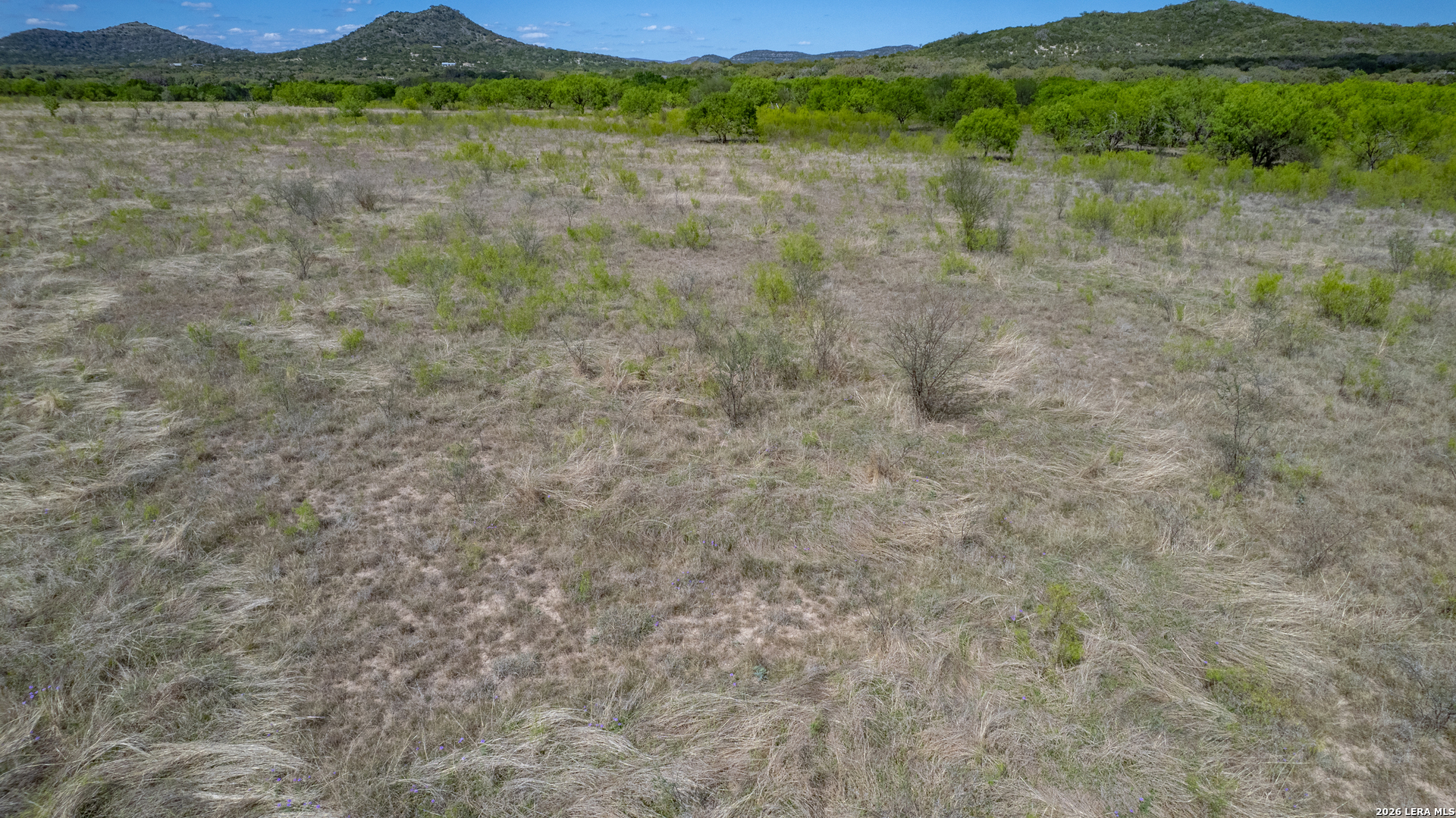 869 Ridge Loop Rio Frio, TX 78879 - Photo 19 of 40 a view of a lush green hillside and a building in the background
