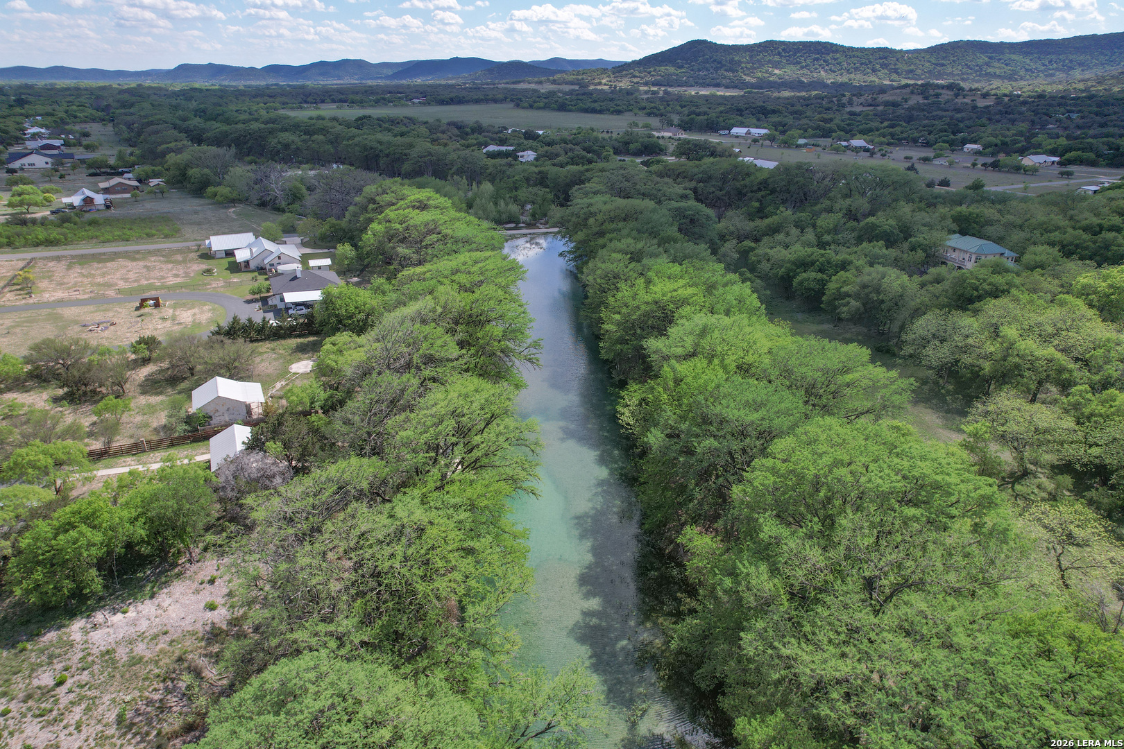 869 Ridge Loop Rio Frio, TX 78879 - Photo 29 of 40 an aerial view of green landscape with trees houses and mountain view