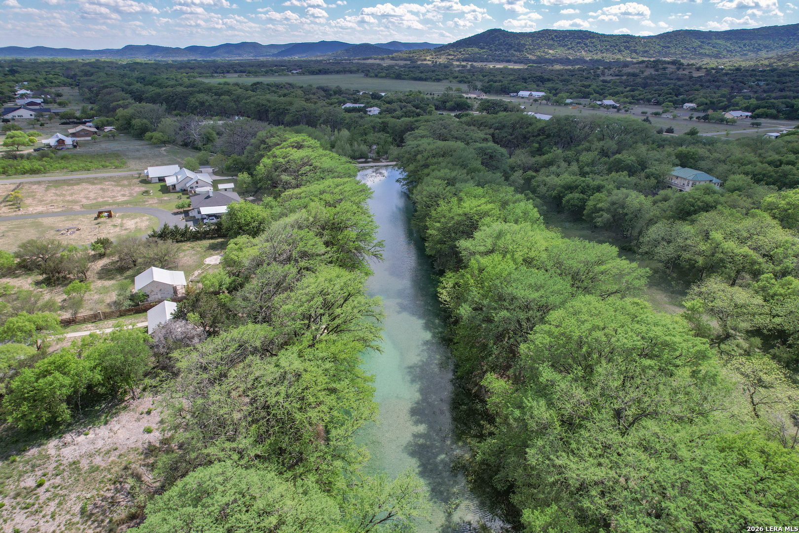 869 Ridge Loop Rio Frio, TX 78879 - Photo 30 of 40 an aerial view of green landscape with trees houses and mountain view