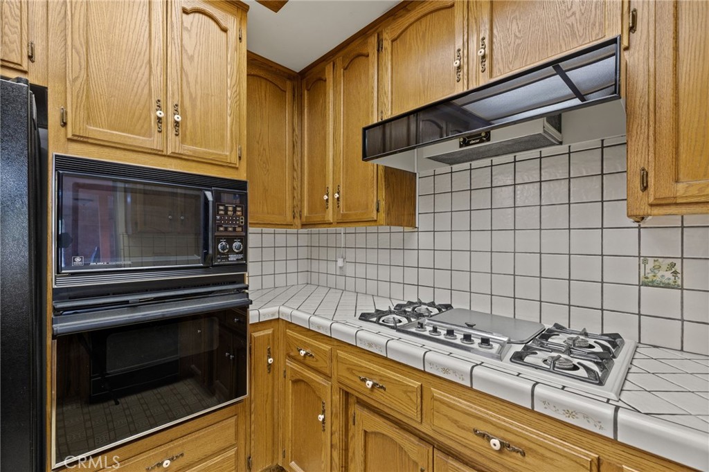 2065 Jenkins Road Bakersfield, CA 93314 - Photo 16 of 59 a kitchen with wooden cabinets and a stove top oven