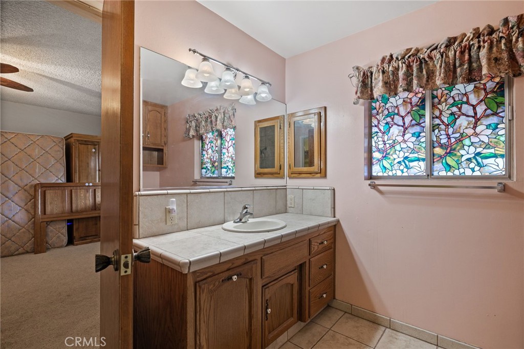 2065 Jenkins Road Bakersfield, CA 93314 - Photo 37 of 59 a bathroom with a sink a vanity and a mirror