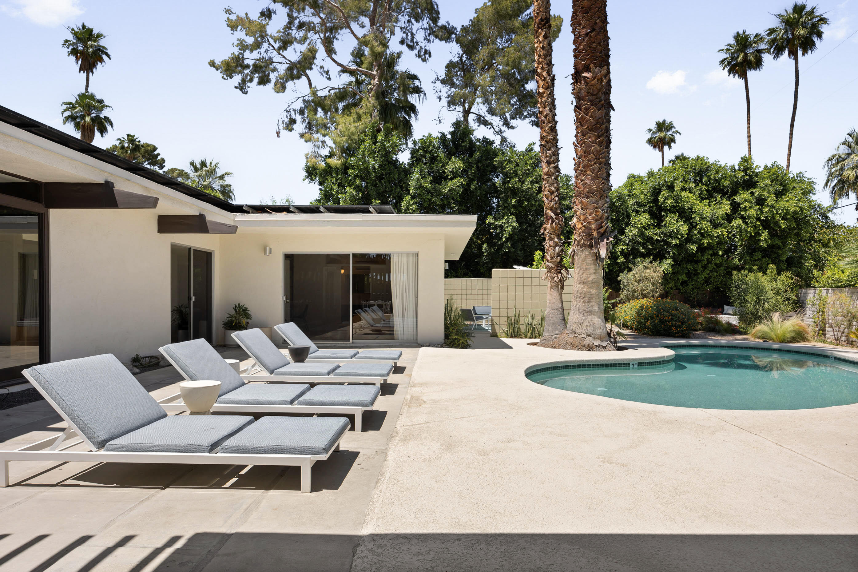 74110 Covered Wagon Trail Palm Desert, CA 92260 - Photo 18 of 44 a view of a patio with a dining table and chairs with a fire pit and potted plants