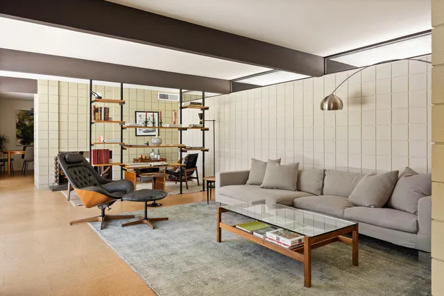 a living room with furniture and floor to ceiling window