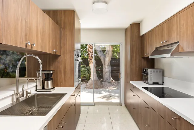 a bedroom with a bed a table and large window