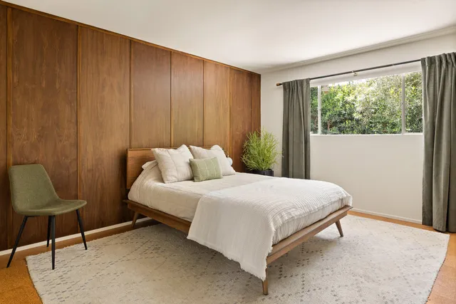 a bedroom with a bed and a large window