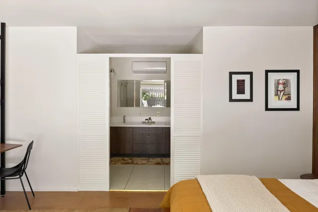 a bedroom with a bed and large windows