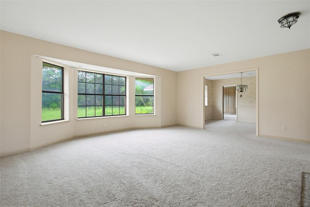 220 Green Ridge Drive Double Oak, TX 75077 - Photo 6 of 25 A row of windows in the living area overlook the expansive backyard