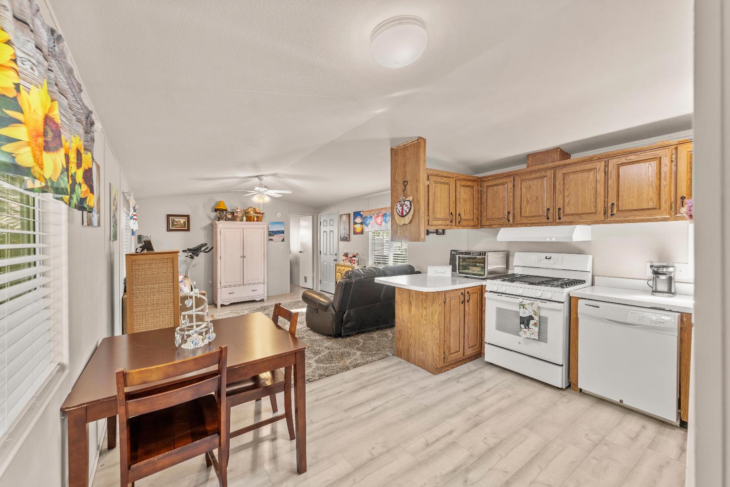 135 Ponderosa Way, Unit 2 Colfax, CA 95713 - Photo 12 of 33 a open kitchen with stainless steel appliances granite countertop a stove top oven a sink dishwasher and white cabinets with wooden floor