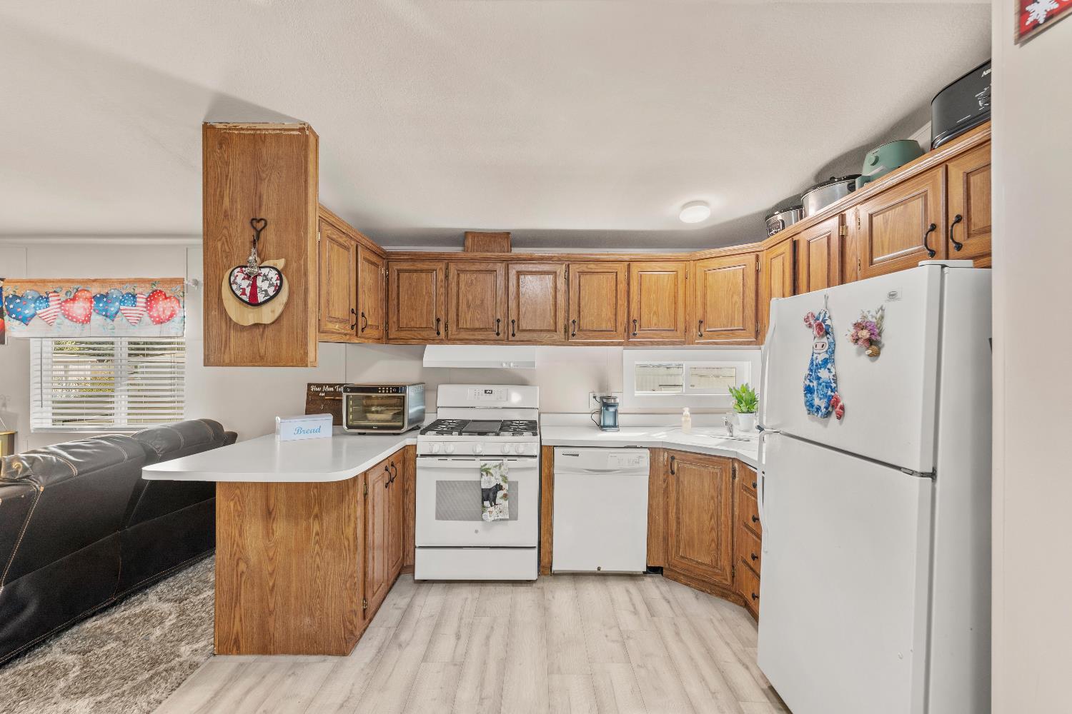 135 Ponderosa Way, Unit 2 Colfax, CA 95713 - Photo 13 of 33 a kitchen with stainless steel appliances granite countertop a refrigerator a sink dishwasher a stove and white countertops with wooden floor