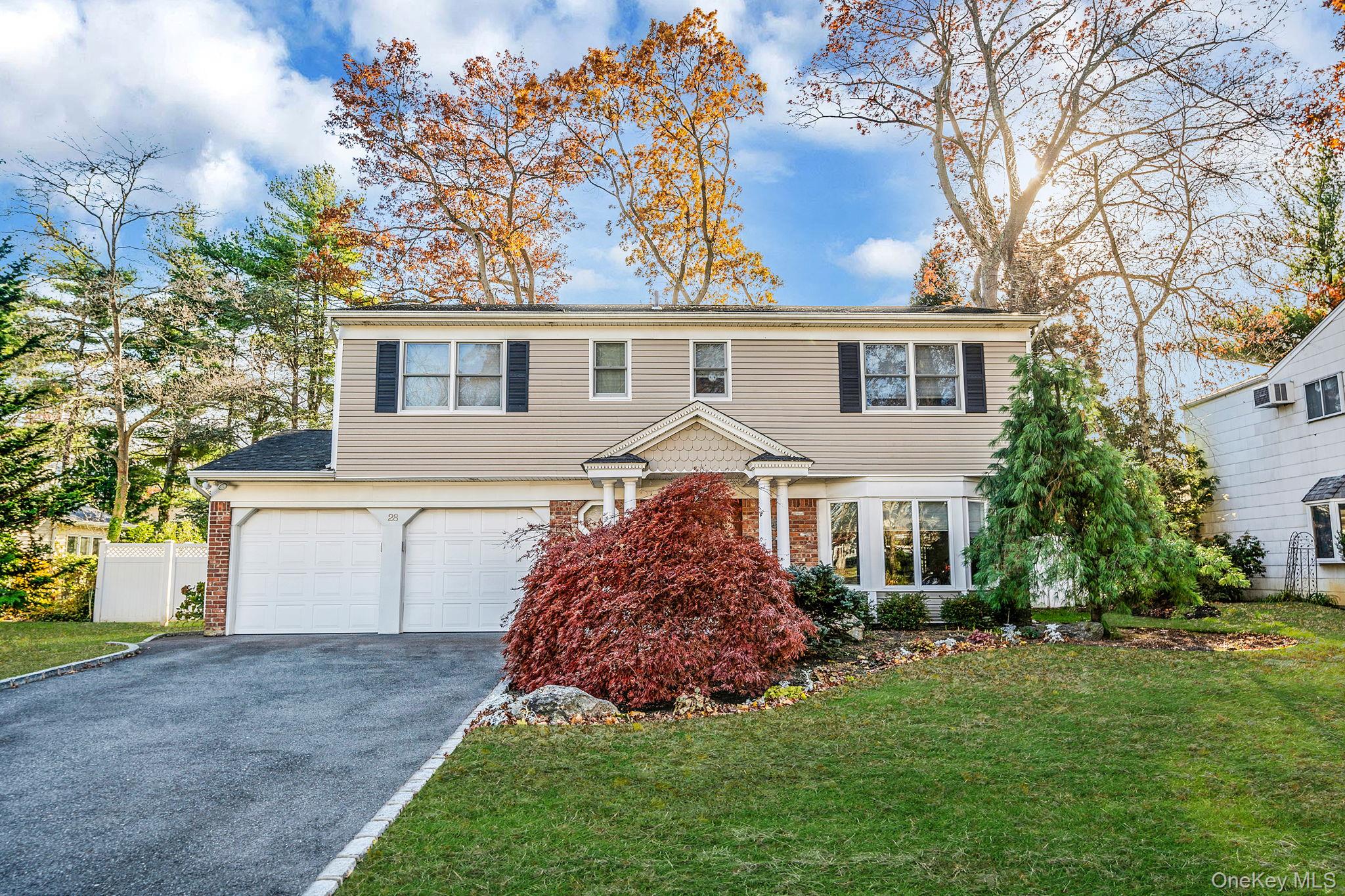 28 Cedarwood Lane Commack, NY 11725 - Photo 1 of 1 a front view of a house with a garden and yard