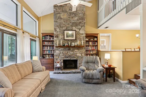 a living room with furniture a fireplace and a floor to ceiling window