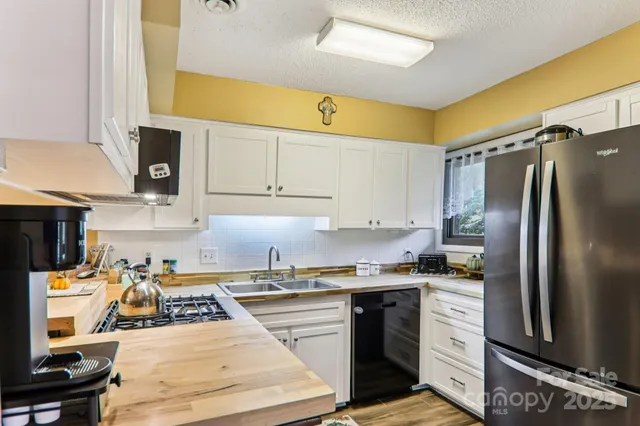 a kitchen with a sink a stove a refrigerator and cabinets