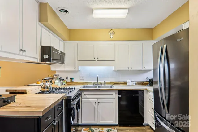 a kitchen with stainless steel appliances granite countertop a sink stove and white cabinets